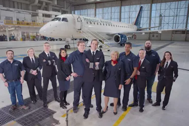 a group of people standing in a hangar