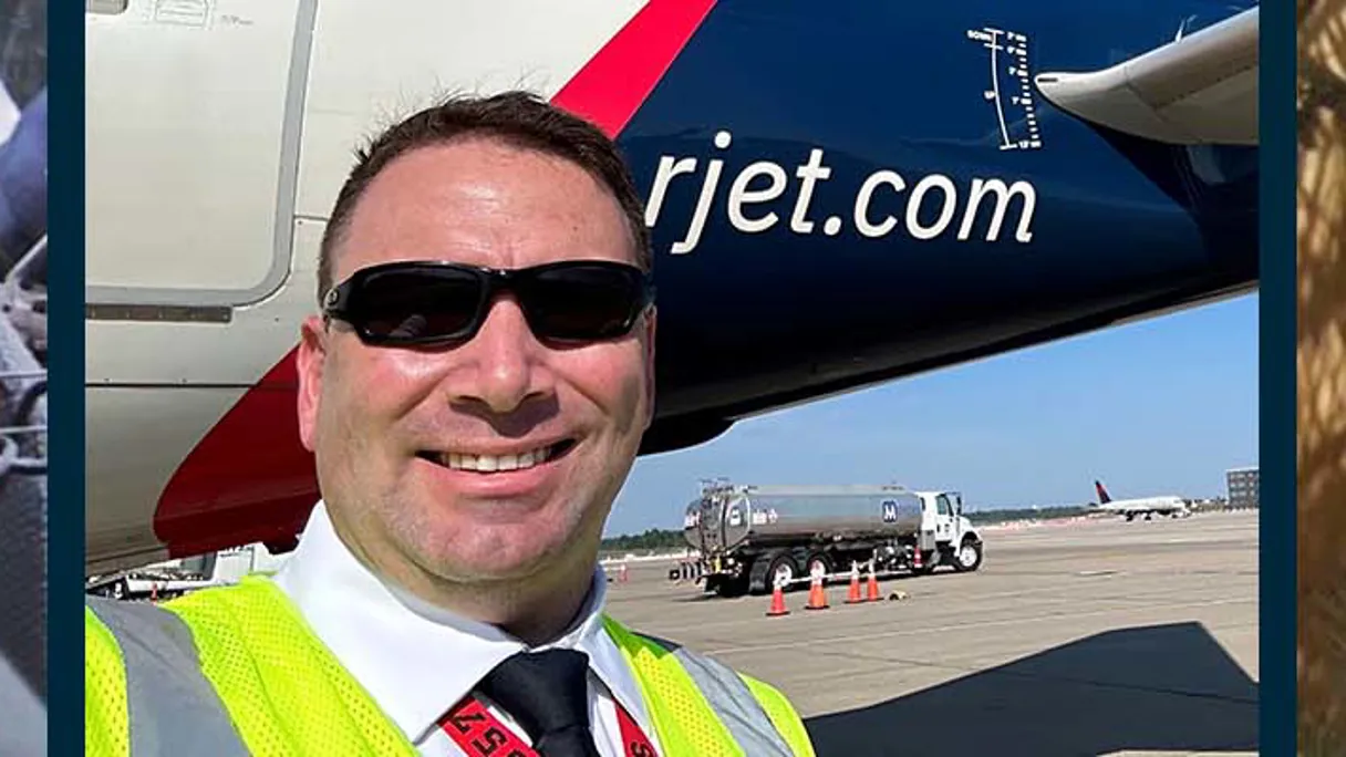 a person in sunglasses and a vest smiling